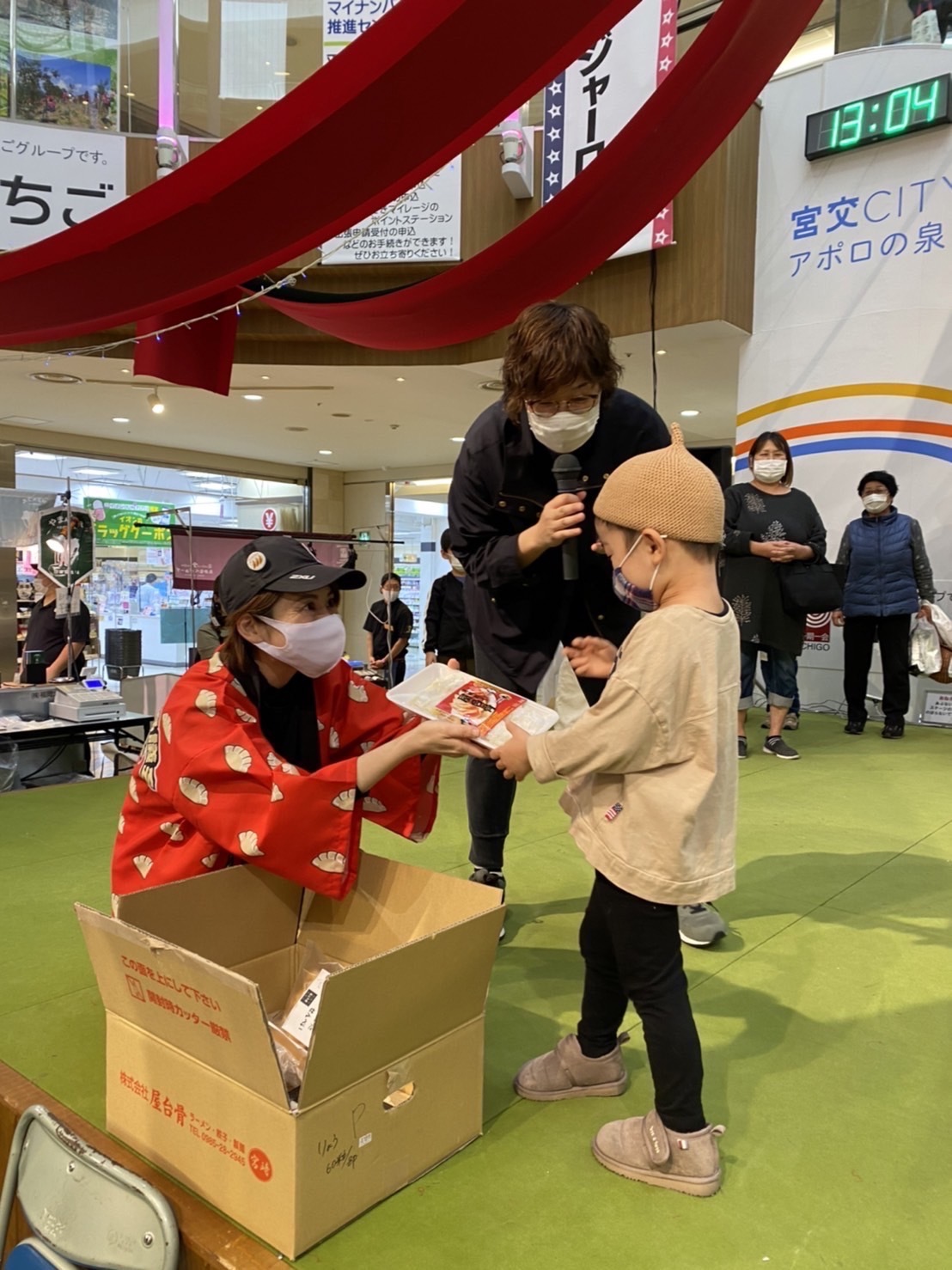 PRイベントで子どもに餃子を手渡すシーン