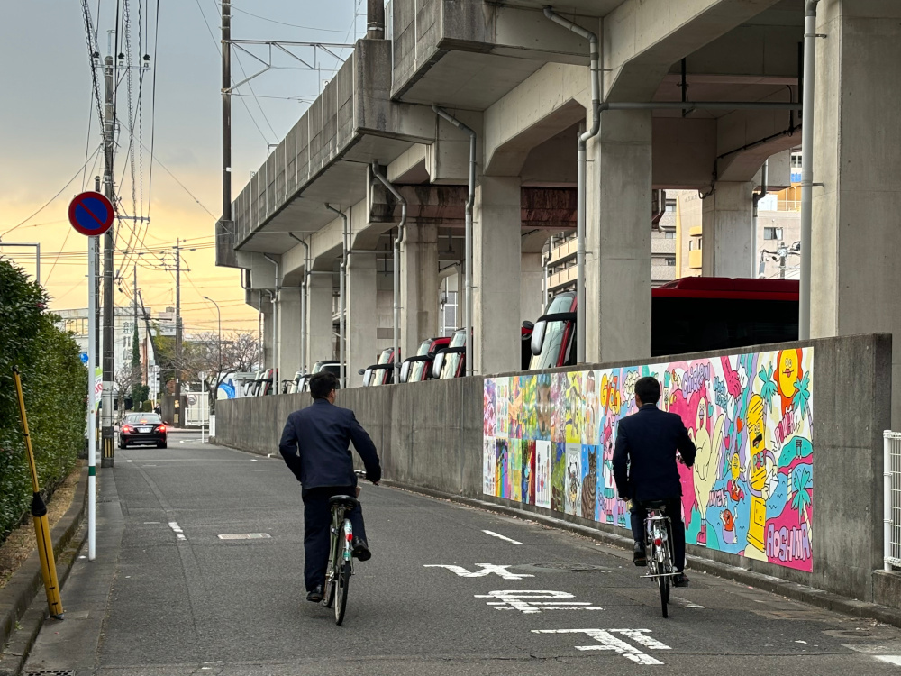 ウォールアートの前を通行する市民