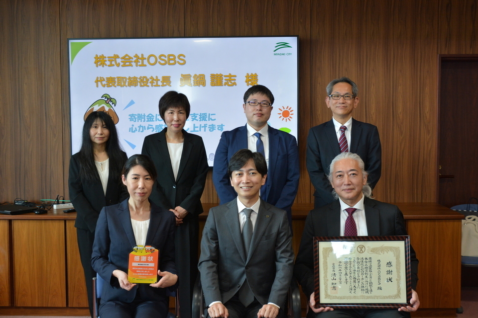 感謝状を手に持つ7人の集合写真