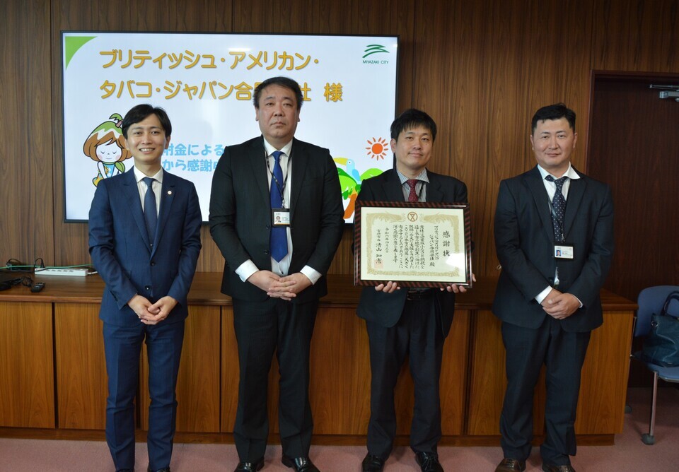 感謝状を手に持つ4人の集合写真