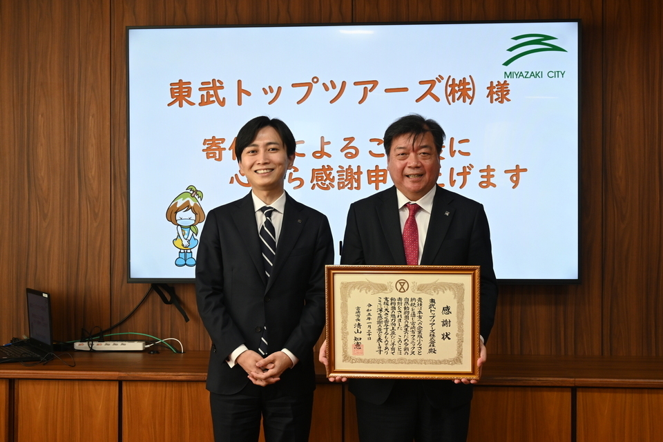 市長と感謝状を手に持つ草場部長の写真